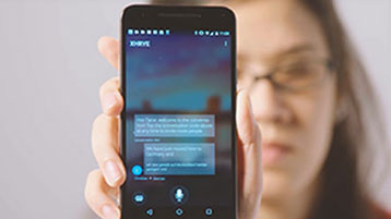A woman holding up her phone to the camera showing the Translator live feature in action